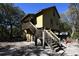 Elevated home with wooden stairs and deck, situated in a wooded area at 39716 Tworut Rd, Webster, FL 33597