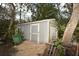 Grey storage shed with double doors in backyard at 39716 Tworut Rd, Webster, FL 33597