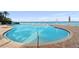 Community pool with water, chairs, and an umbrella at 4951 Bacopa S Ln # 302, St Petersburg, FL 33715