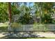 Charming house exterior with a white picket fence and tropical plants at 602 Maryland Ave, Crystal Beach, FL 34681