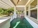 Green floor porch with white railing and ceiling fan at 6715 32Nd N St, St Petersburg, FL 33702