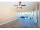 Bright living room with tiled floors, ceiling fan, and sliding glass doors leading to outdoor space at 7400 Sun Island S Dr # 104, South Pasadena, FL 33707