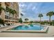 Community pool with lounge chairs and palm trees at 7400 Sun Island S Dr # 104, South Pasadena, FL 33707