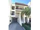 Condo building entrance with stairs, garage, and landscaping at 126 1St E St # 209, Tierra Verde, FL 33715