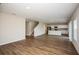 Open-concept living room with hardwood floors and a view of the kitchen and stairs at 12990 Wellspring Dr, Lithia, FL 33547