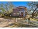 Two-story house with a red door, white picket fence, and mature trees at 1530 22Nd S Ave, St Petersburg, FL 33705