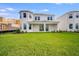 Well-manicured backyard highlights a spacious lawn and the home's architectural details at 1979 Longliner Loop, Wesley Chapel, FL 33543