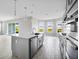 Modern kitchen features an island with stainless appliances, stylish backsplash, and bright natural light at 1979 Longliner Loop, Wesley Chapel, FL 33543