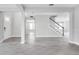 A spacious living room featuring modern gray floors and plenty of natural light from the entryway at 1979 Longliner Loop, Wesley Chapel, FL 33543
