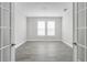A view into a well-lit office with gray tiled floor, white trim and windows with horizontal blinds at 1979 Longliner Loop, Wesley Chapel, FL 33543