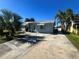 Ranch home with a large driveway and tropical landscaping at 2215 Riomar Dr, Holiday, FL 34691