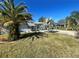 Ranch style home with palm trees and a well-manicured lawn at 2215 Riomar Dr, Holiday, FL 34691