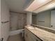Bathroom features a granite vanity, bright lighting, framed mirror, and shower-tub combo at 2617 Cove Cay Dr # 505, Clearwater, FL 33760