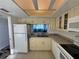 Bright kitchen with granite countertops, classic cabinetry, and water views from the window above the sink at 2617 Cove Cay Dr # 505, Clearwater, FL 33760