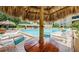 Resort-style pool area with lounge chairs and a shady tiki hut, perfect for relaxation at 2617 Cove Cay Dr # 505, Clearwater, FL 33760