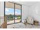 Bedroom with a crib, recliner, and balcony access overlooking pool at 2912 W Santiago St # 404, Tampa, FL 33629