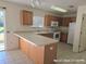 Galley kitchen with wood cabinets, white appliances, and tile flooring at 3019 Bear Oak Dr, Valrico, FL 33594