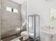 Modern bathroom featuring a walk-in tiled shower and pedestal sink with decorative mirror at 34 Concord Dr, Dunedin, FL 34698