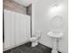Stylish bathroom featuring a shower with white curtain, toilet, and pedestal sink at 34 Concord Dr, Dunedin, FL 34698
