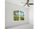 Well-lit empty bedroom featuring a large arched window overlooking lush greenery at 34 Concord Dr, Dunedin, FL 34698