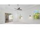 Bright bedroom with ceiling fan and sliding doors, leading to covered lanai and outdoor grill at 34 Concord Dr, Dunedin, FL 34698