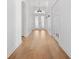 Bright hallway featuring hardwood floors and decorative lighting, leading to double doors at 34 Concord Dr, Dunedin, FL 34698