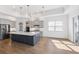 Modern kitchen featuring a large island with pendant lighting, stainless steel appliances, and pantry at 34 Concord Dr, Dunedin, FL 34698