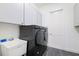 Well-equipped laundry room with new washer and dryer units and ample cabinet space at 34 Concord Dr, Dunedin, FL 34698