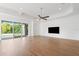 Open living room with tray ceiling, wood floors, and access to pool through sliding glass doors at 34 Concord Dr, Dunedin, FL 34698