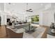 Bright living room with ceiling fan, hardwood floors, and sliding glass doors leading to the pool at 34 Concord Dr, Dunedin, FL 34698