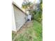 Side view of house showing weathered siding and a small yard at 8305 N Brooks St, Tampa, FL 33604