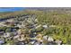 Aerial view of neighborhood, featuring houses nestled amongst trees near a lake at 918 Windward Way, Palm Harbor, FL 34685