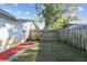 Backyard with grassy area, wooden fence, and firepit area at 918 Windward Way, Palm Harbor, FL 34685