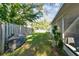 Fenced backyard with grassy area, grill, and screened patio at 918 Windward Way, Palm Harbor, FL 34685