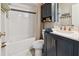 Clean bathroom featuring a bathtub, vanity with quartz countertop and dark cabinets at 918 Windward Way, Palm Harbor, FL 34685
