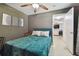 Bedroom with teal bedding, ceiling fan, and view of another room at 918 Windward Way, Palm Harbor, FL 34685