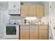 Small galley-style kitchen with white cabinets and appliances at 918 Windward Way, Palm Harbor, FL 34685