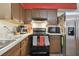 Kitchen corner with stainless steel appliances and wood cabinets at 918 Windward Way, Palm Harbor, FL 34685