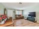 Spacious living room featuring hardwood floors and a large TV at 918 Windward Way, Palm Harbor, FL 34685