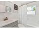 Clean bathroom with white tiled walls, gray vanity, and shower/tub combo at 1114 20Th Sw St, Largo, FL 33770