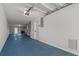 Garage interior with blue epoxy flooring and ample storage at 115 Brent Cir, Oldsmar, FL 34677