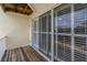 Exterior of home featuring sliding glass doors leading out to a wood balcony with white plantation shutters at 115 Brent Cir, Oldsmar, FL 34677