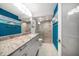 Bathroom with teal walls and granite countertop at 1591 Gulf Blvd # 504S, Clearwater Beach, FL 33767