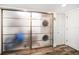 Laundry room with sliding frosted glass doors concealing washer and dryer at 1591 Gulf Blvd # 504S, Clearwater Beach, FL 33767