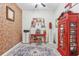 Home office with a red telephone booth and brick feature wall at 16020 Starling Crossing Dr, Lithia, FL 33547