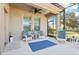 Screened porch with white chairs, blue rug, and ceiling fan at 16020 Starling Crossing Dr, Lithia, FL 33547