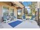 Screened porch with white adirondack chairs and blue rug at 16020 Starling Crossing Dr, Lithia, FL 33547