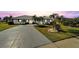 White one-story home with a circular driveway, landscaping, and palm trees at 1906 Wolf Laurel Dr, Sun City Center, FL 33573