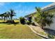 White house exterior with palm trees and landscaped yard at 1906 Wolf Laurel Dr, Sun City Center, FL 33573