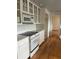 White kitchen with wood floors, glass cabinets, and built-in appliances at 200 Carmona Ne Way, St Petersburg, FL 33704